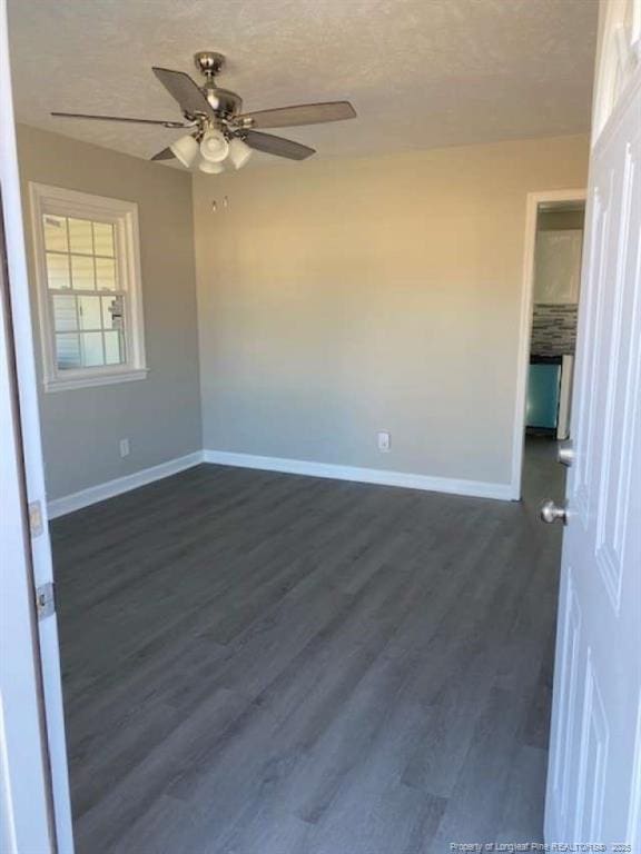 spare room featuring ceiling fan, dark hardwood / wood-style flooring, and a textured ceiling