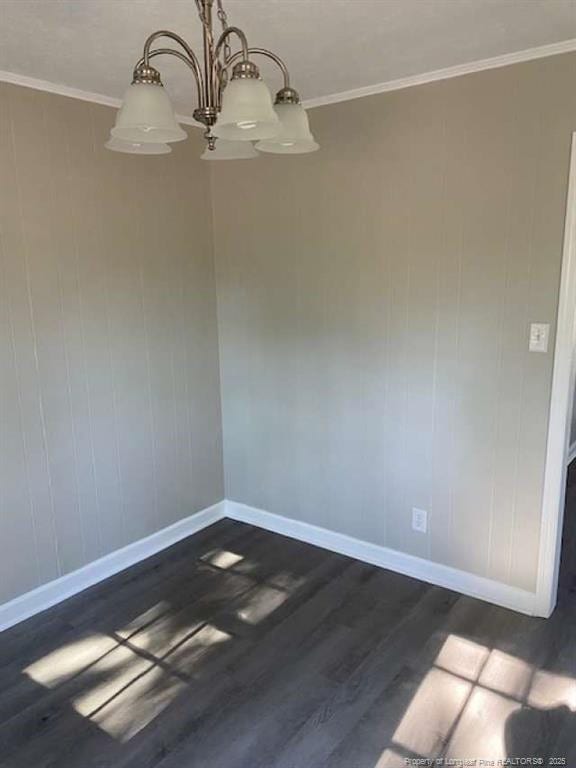 unfurnished room featuring dark hardwood / wood-style flooring, ornamental molding, and a chandelier