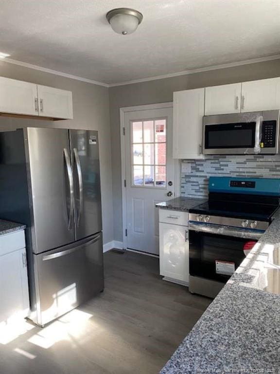 kitchen with appliances with stainless steel finishes, backsplash, stone countertops, and white cabinetry