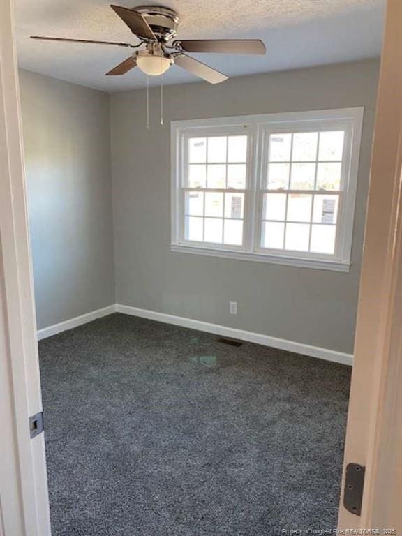 carpeted empty room with ceiling fan and a textured ceiling