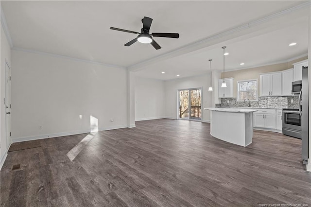 kitchen featuring ceiling fan, white cabinets, pendant lighting, a kitchen island, and appliances with stainless steel finishes