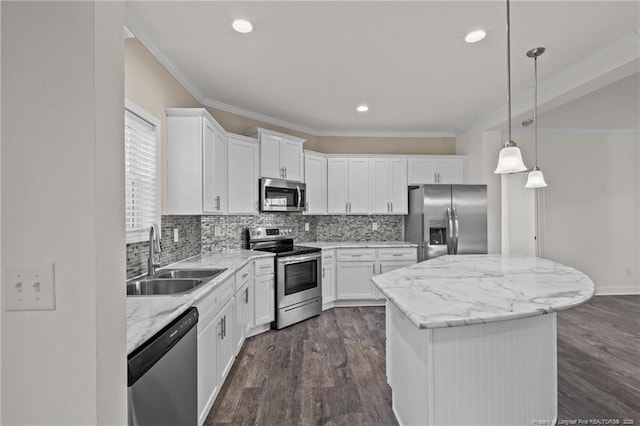 kitchen featuring appliances with stainless steel finishes, white cabinetry, a kitchen island, and sink