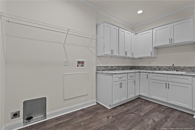 washroom with cabinets, washer hookup, dark hardwood / wood-style flooring, ornamental molding, and sink