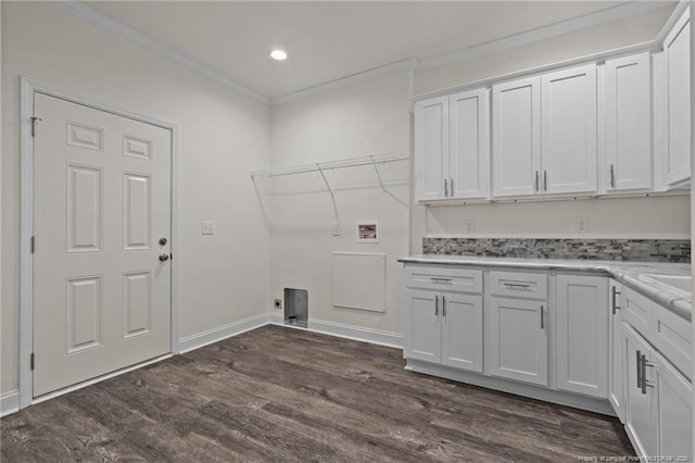 clothes washing area with crown molding, cabinets, dark wood-type flooring, and hookup for a washing machine