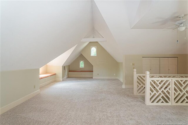 additional living space with a ceiling fan, carpet flooring, baseboards, and lofted ceiling
