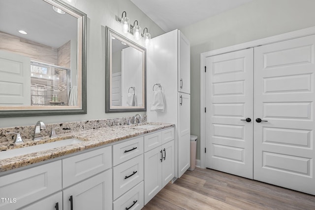 bathroom featuring hardwood / wood-style floors, vanity, and an enclosed shower