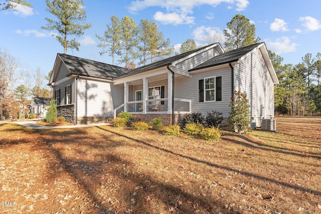 view of front facade featuring covered porch, a front yard, and central AC