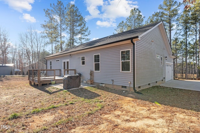 rear view of property featuring a deck and a garage