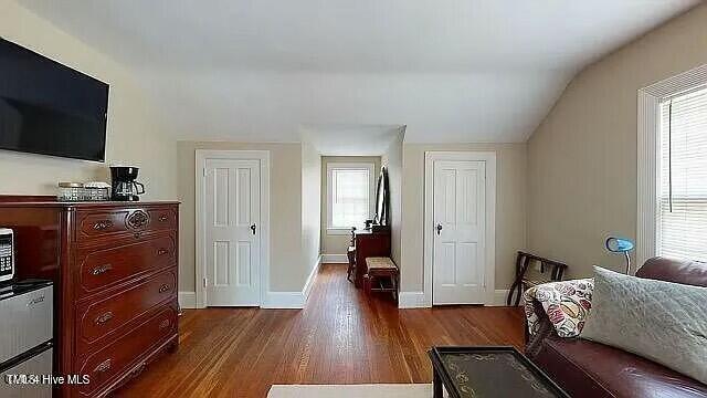 living room with vaulted ceiling and dark wood-type flooring