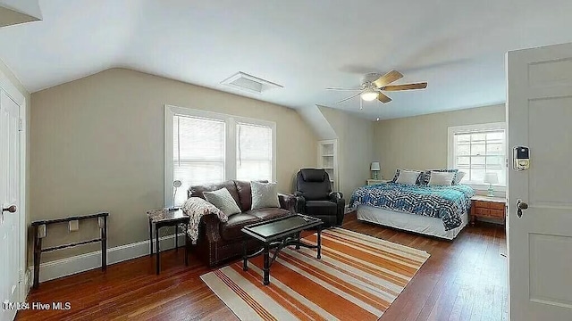 bedroom featuring ceiling fan, dark hardwood / wood-style flooring, multiple windows, and vaulted ceiling