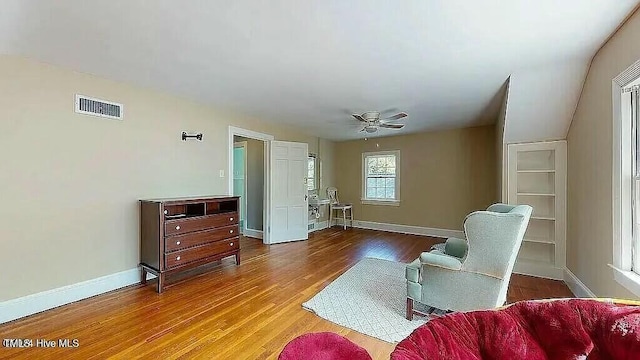 living area with hardwood / wood-style flooring and ceiling fan