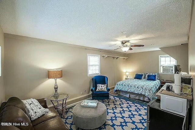 bedroom featuring multiple windows, a textured ceiling, ceiling fan, and cooling unit