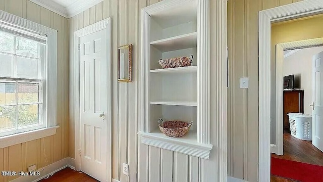 entryway with built in shelves and crown molding