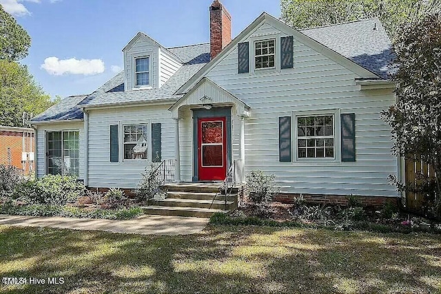 cape cod home with a front lawn