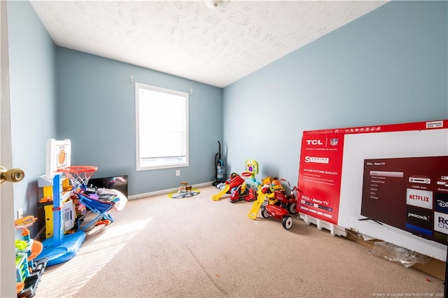 playroom with a textured ceiling and carpet floors