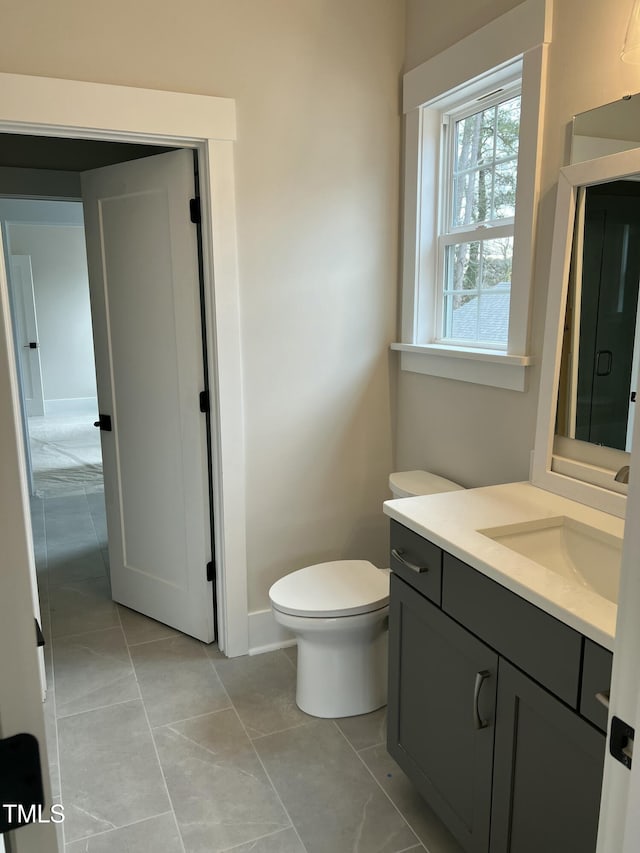 bathroom with tile patterned flooring, vanity, and toilet