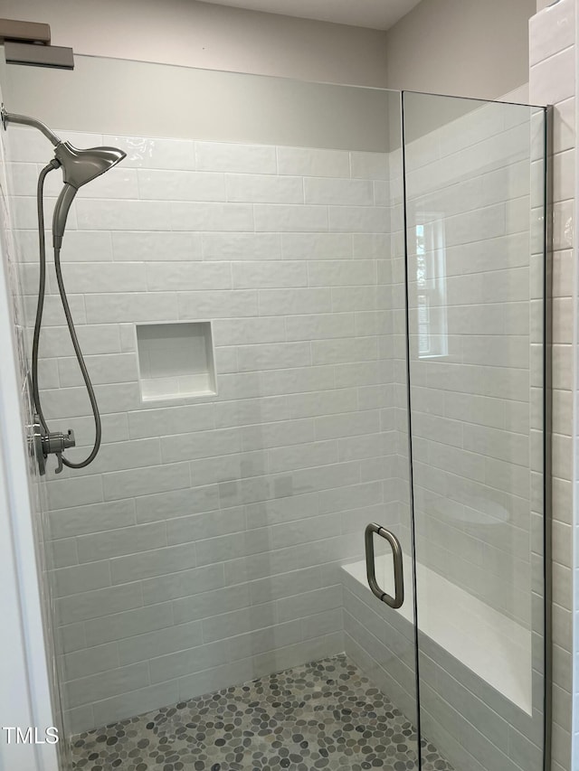 bathroom featuring a shower with door