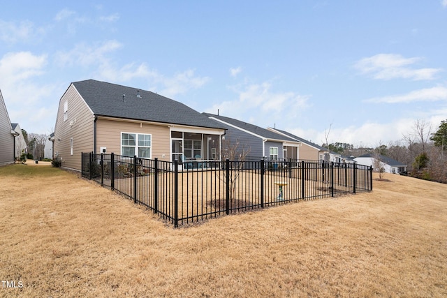 back of house featuring a sunroom and a lawn