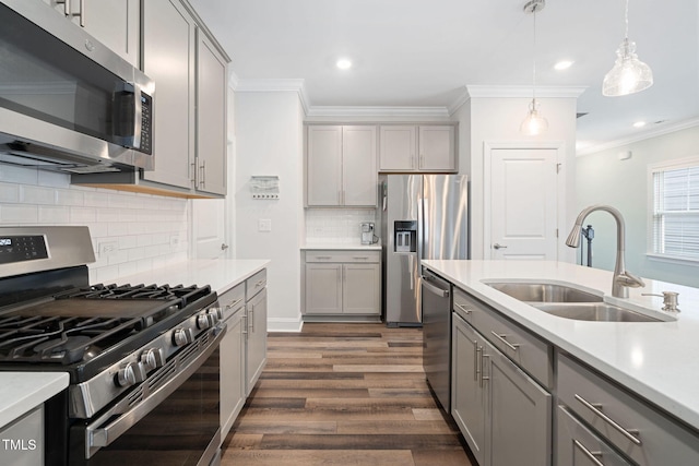 kitchen with appliances with stainless steel finishes, pendant lighting, sink, gray cabinetry, and decorative backsplash