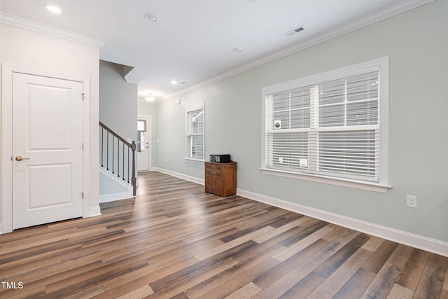 unfurnished living room with crown molding and dark wood-type flooring