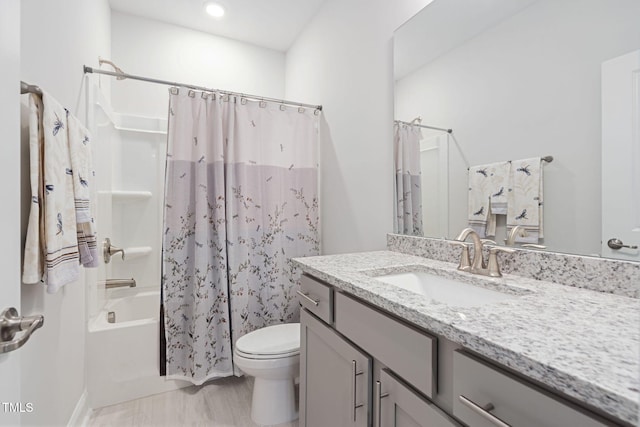 full bathroom with vanity, shower / tub combo, and toilet