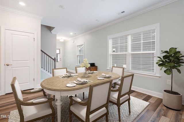 dining area with crown molding and dark hardwood / wood-style flooring