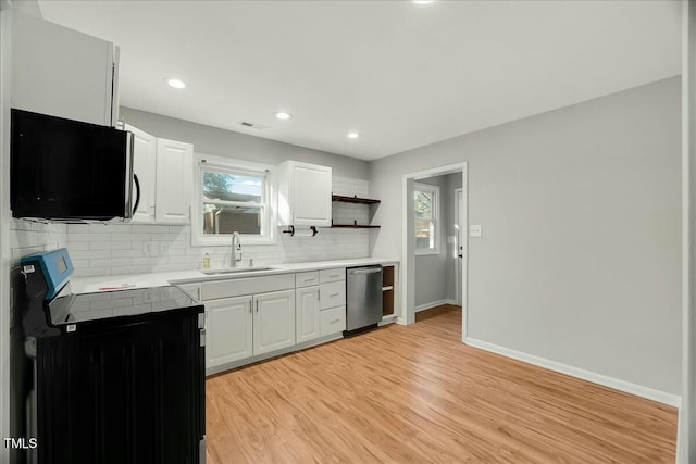 kitchen featuring sink, tasteful backsplash, stainless steel dishwasher, stove, and white cabinets