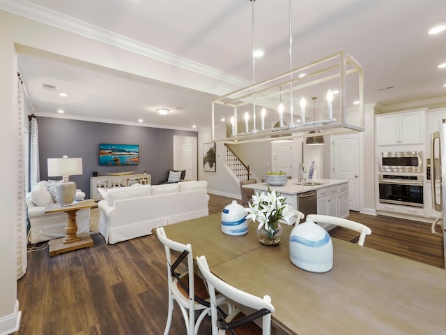 dining area featuring dark hardwood / wood-style floors, crown molding, and sink