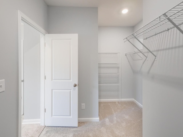 spacious closet featuring light carpet