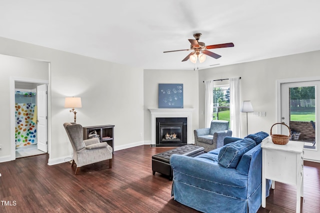 living room featuring ceiling fan and dark hardwood / wood-style flooring