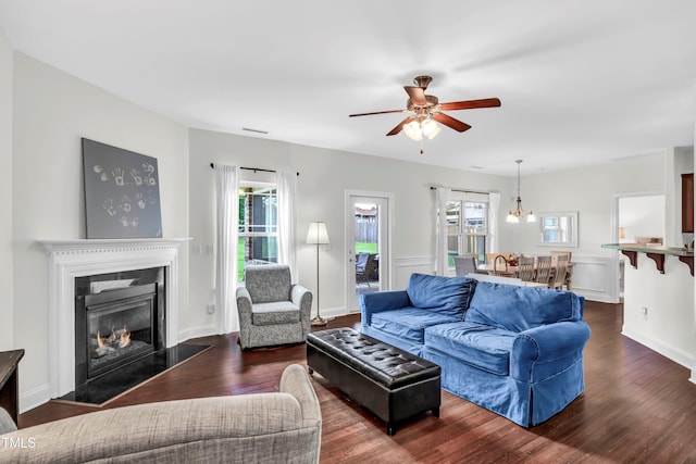 living room with ceiling fan and dark wood-type flooring