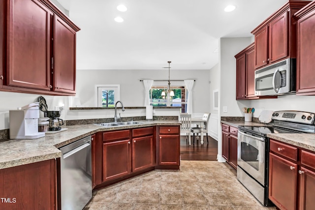 kitchen with hanging light fixtures, sink, and stainless steel appliances