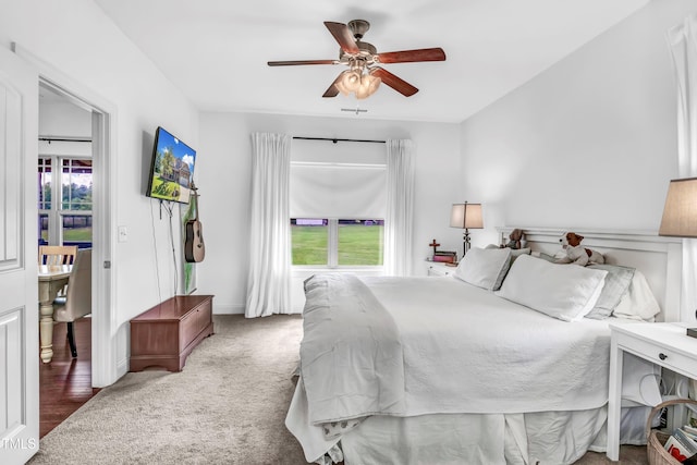 carpeted bedroom featuring ceiling fan and multiple windows