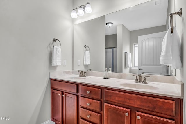 bathroom featuring a shower with shower door and vanity