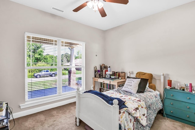 carpeted bedroom with ceiling fan and multiple windows