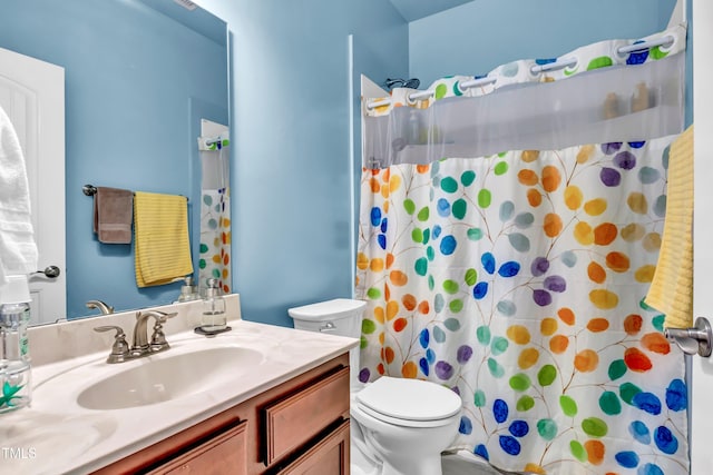 bathroom with toilet, vanity, and a shower with shower curtain