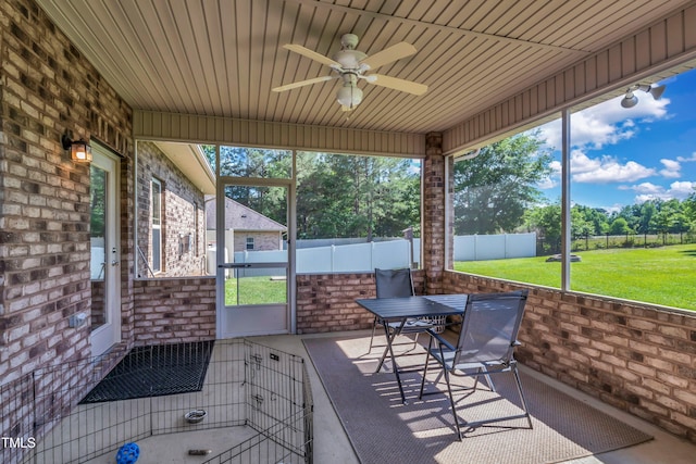 unfurnished sunroom featuring ceiling fan