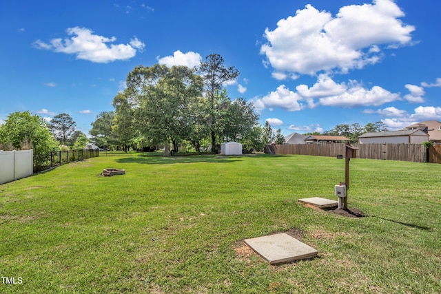 view of yard featuring an outdoor fire pit and a storage unit