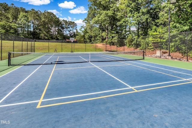 view of sport court featuring a yard and basketball hoop