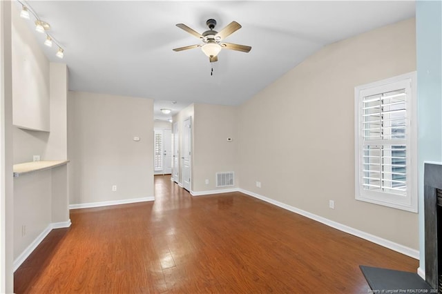 unfurnished living room featuring ceiling fan, a healthy amount of sunlight, lofted ceiling, and wood-type flooring