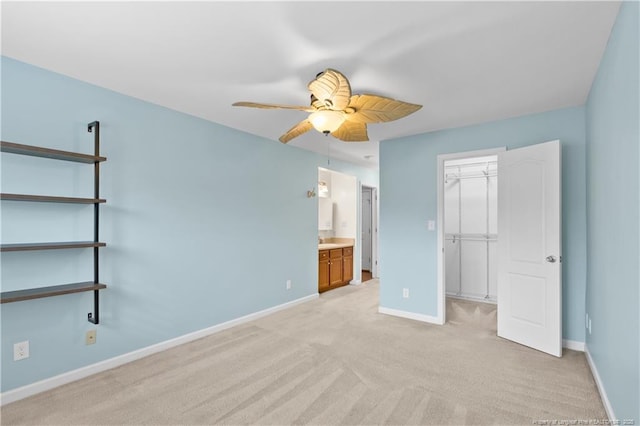 unfurnished bedroom featuring ceiling fan, light carpet, connected bathroom, and a closet