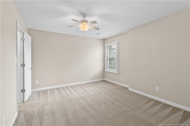 empty room featuring ceiling fan and light colored carpet