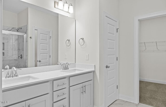 bathroom featuring a shower with door and vanity