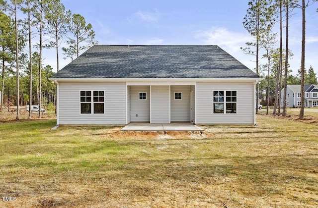 rear view of house with a patio and a lawn