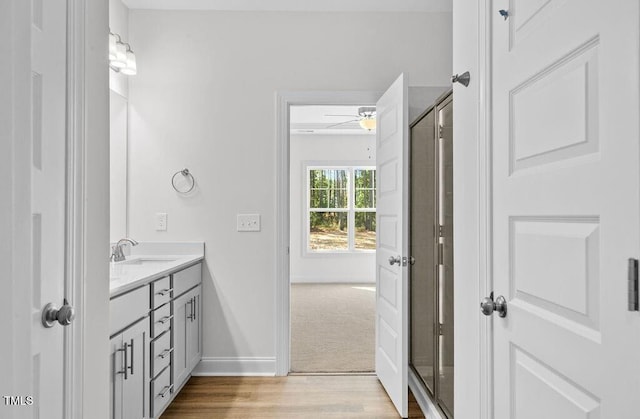 bathroom featuring hardwood / wood-style floors, vanity, ceiling fan, and a shower with door