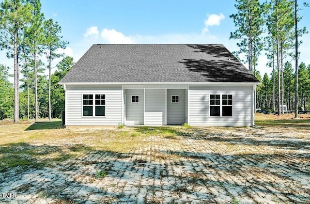 rear view of property featuring a lawn