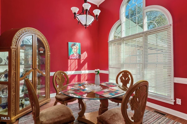 dining space featuring a healthy amount of sunlight, hardwood / wood-style flooring, and a notable chandelier