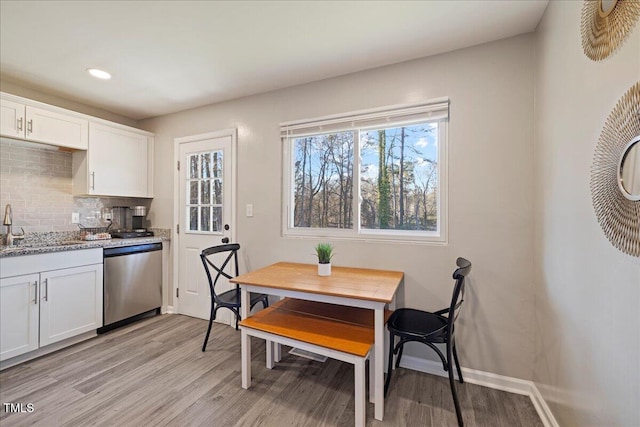 dining area with light hardwood / wood-style flooring and sink