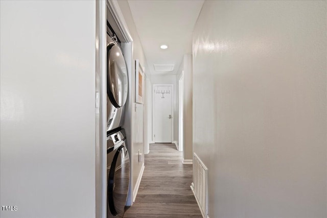 laundry area featuring light hardwood / wood-style floors and stacked washer and clothes dryer