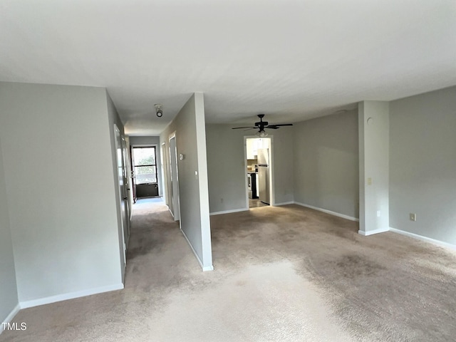 carpeted spare room featuring ceiling fan